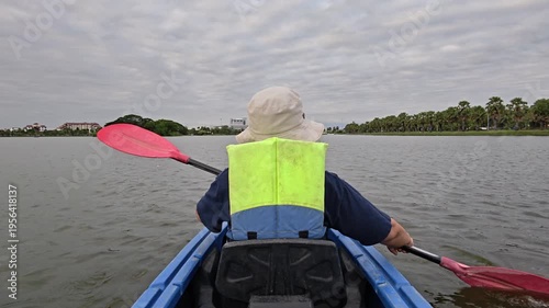 A woman paddle kayak at the lake, sunset background	
