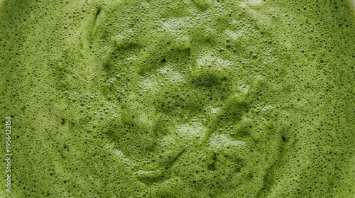 Macro texture of matcha foam with tiny bubbles. Green tea latte beverage background concept.