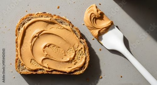 Delicious Peanut Butter Toast with Spatula on Gray Surface.