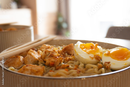 Delicious bowl of ramen noodles with chicken and soft-boiled eggs, ready to eat