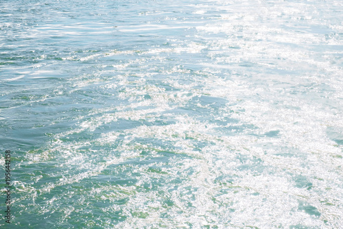 Auckland, New Zealand: Sunlight reflecting off the choppy blue water of the Waitemata Harbour during a ferry crossing