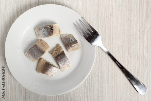 Pickled herring on plate. Salted, soused skinless slices of fish Clupea.