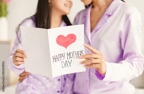 Obraz na płótnie Two people are sharing a special moment on Mother's Day while reading a card