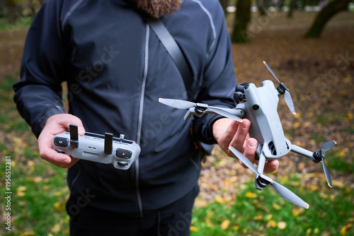 Tableau sur toile Man holds drone and controller, preparing for flight