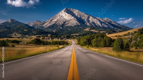 Road leading to mountain range under blue sky and white clouds