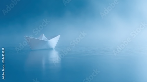 Lonely white paper boat drifting on calm blue water with mist, minimal emotional concept