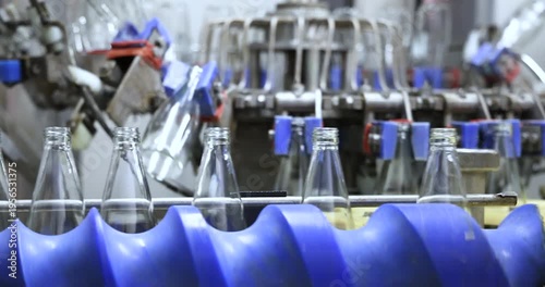 Empthy bottles on a conveyor belt in bottling process at a factory