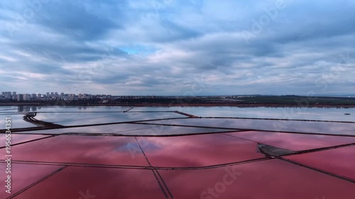 Large pink salty lakes against cloudy sky. Salt production industry. Aerial view.