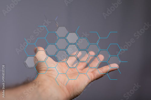Hand holding holographic data connection concept. Futuristic digital technology with hexagonal design. Communication and