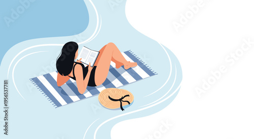 Woman lying on a striped towel and reading a book on a sunny beach with a straw hat beside her for a relaxing summer vacation.