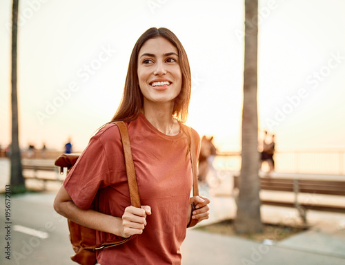 Portrait of a smiling young woman girl walking in the city, tourists visiting destination, summer trip exploring