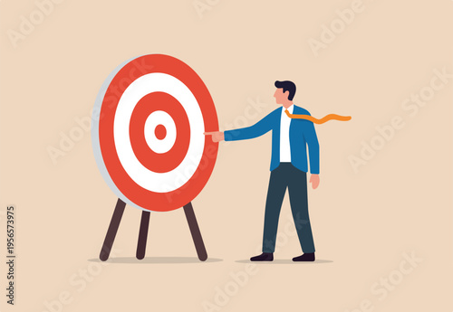Specific goal, clarify objective or target, focus or concentrate on purpose to win business mission, businessman pointing at center of bullseye