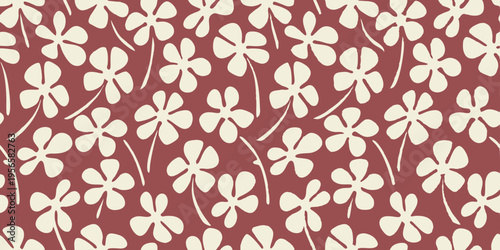 Seamless pattern shows whimsical light floral elements scattered on deep red background