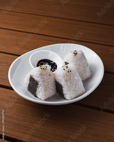 Fotografi White plate holds three rice balls with seaweed