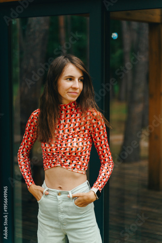 Young woman portrait near glass wall in forest cabin