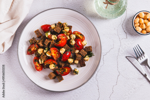 Salad of rye bread, cherry tomatoes and smoked cheese on a plate on the table top view