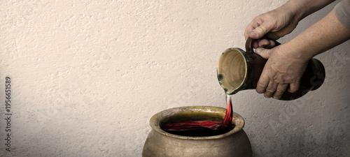Foto A hand holds a clay jar and pours water