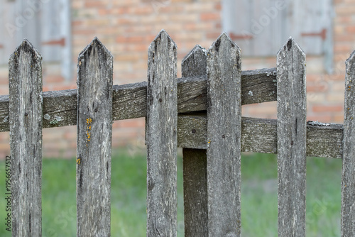 Old picket fence around an abandoned house.Uninhabited abandoned plot in the countryside.