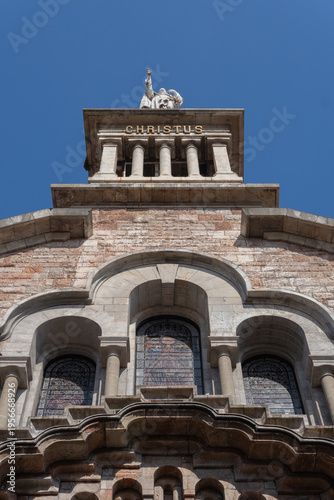 Description: Low angle view of the stone statue of Christ and the decorative facade with stained glass of the Basilica del Sagrado Corazon de Jesus.