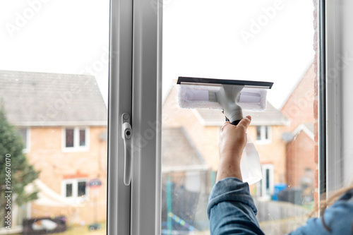 Foto Hand using squeegee to clean window glass indoors, household chore, hygiene care, cleaning routine