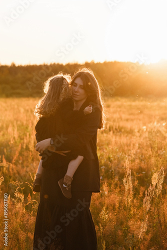 Mother And Daughter Walk Peacefully. Serene Countryside Scene With Mother And Child At Sunset. Calm Rural Evening Walk Featuring Mother And Daughter Amid Open Fields And Distant Trees