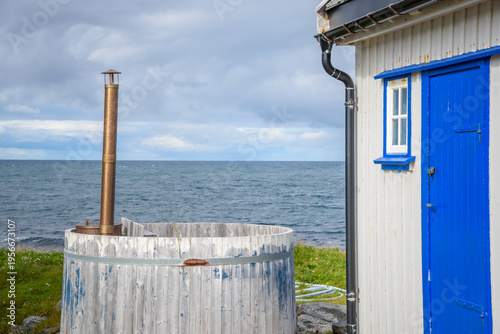 Wood Fired Hot Tub with White Cabin and Bright Blue Door at Kjølnes Lighthouse Station, Berlevåg, Finnmark, Norway