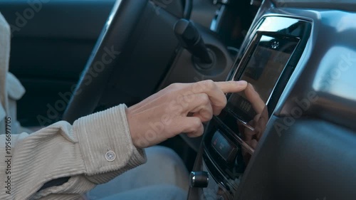 Businessman interacting with car navigation system. Businessman inside a modern car is interacting with the navigation system, touching the screen and using gestures to browse the map