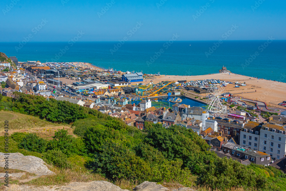 Naklejka premium People are enjoying a sunny day on a beach in Hastings, England