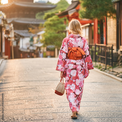 和服姿の外国人女性が日本の観光地を散策する笑顔のビジュアル、文化体験や旅行の魅力を表現したシーン、街並みや歴史的な背景と調和した雰囲気、観光広告や動画素材としても活用できる印象的な構図