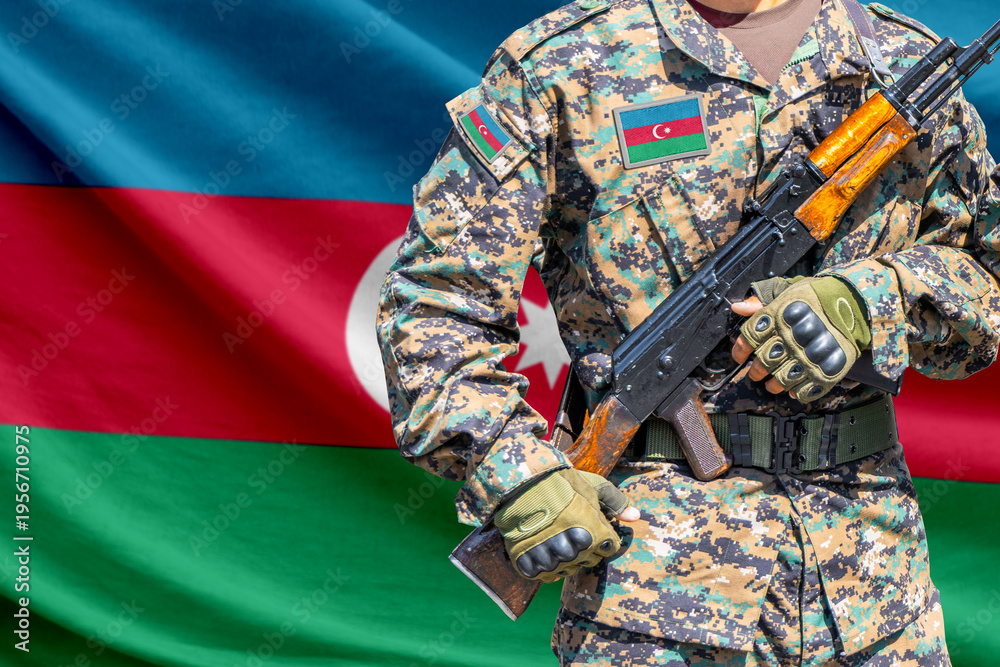 Fototapeta premium Azerbaijan flag with soldier in military uniform holding assault rifle in front of it