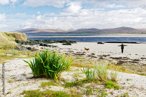 Photos Walking dog on quiet remote beach on Gruinart Bay at Ardnave Point, Islay, Inner Hebrides