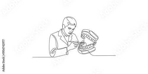 Dentist examining a large model of human teeth with dental tool in one hand examine