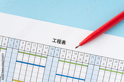 水色背景に工程表と赤いペン