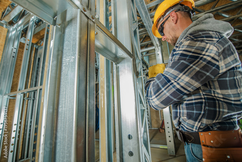 Worker Installs Metal Framing in Construction Site