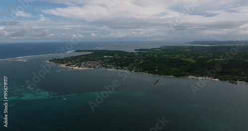 Wallpaper Mural A coastal village lies along the shoreline with coral reef waters and cloudy sky over the sea. Siargao, Philippines. Torontodigital.ca