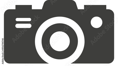A grayscale icon of a camera, featuring a lens, buttons, and a rounded rectangular shape