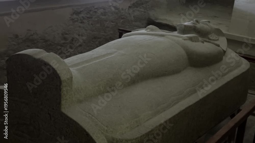 Static shot of the massive red granite anthropoid sarcophagus of Pharaoh Merenptah inside tomb KV8 in the Valley of the Kings