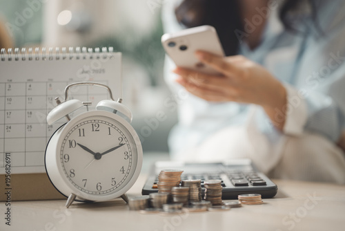 Smartphone bill payment reminder with calendar, alarm clock and coins representing recurring payments, budgeting, expense tracking and personal finance management.