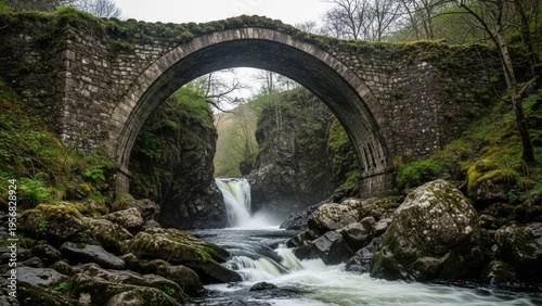A serene stone bridge spans a rocky river with a waterfall