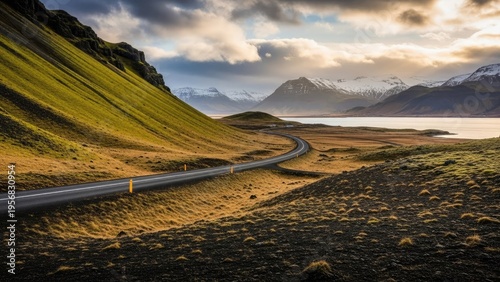 A winding road stretches through a scenic landscape with mountains and water