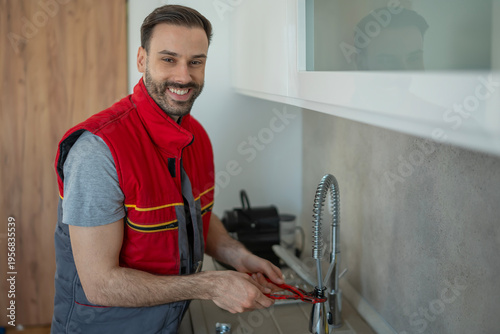 Fotografía Plumber repairing kitchen faucet for home service