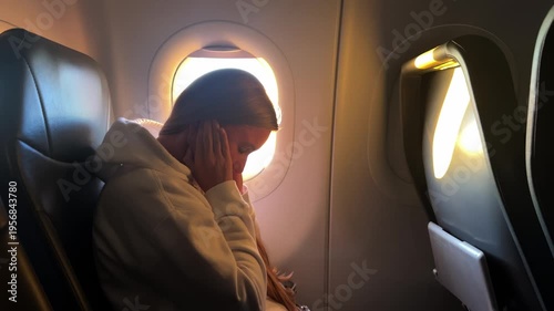 Stressed woman with headache flying on airplane