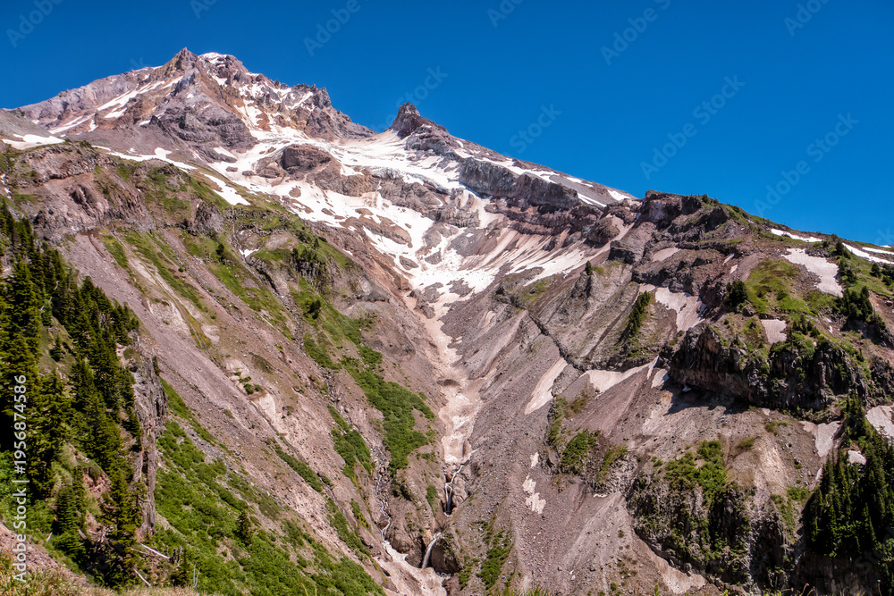 Fototapeta premium Rugged mountain peak gleams under clear blue sky