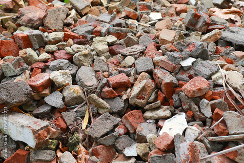 A high-angle shot of a dense pile containing broken red bricks and grey concrete construction debris
