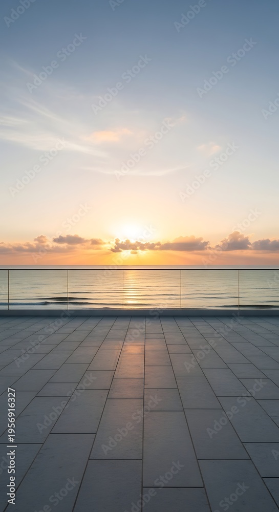 Naklejka premium Serene ocean sunrise viewed from a modern balcony with tiled flooring and glass railings, casting a peaceful glow over the calm water and sky.
