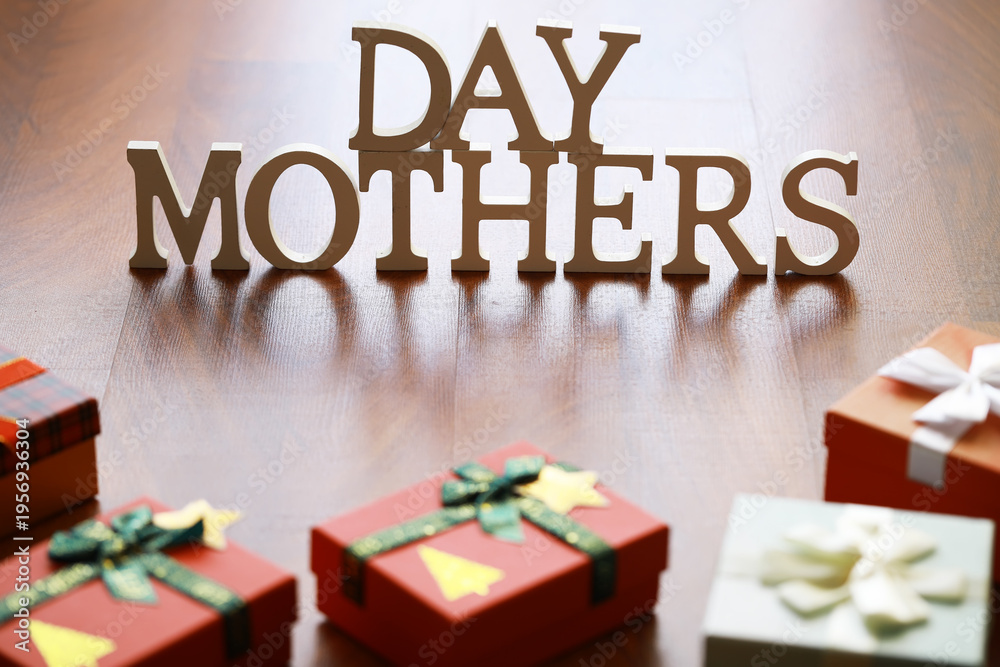 Obraz premium Mother's Day Celebration: Gift Boxes and Wooden Letters on a Wooden Surface