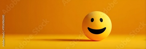 A vibrant yellow textured sphere depicting a classic happy smiley face expression positioned on a smooth matching orange background with soft studio l