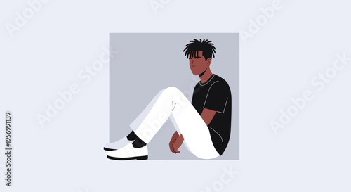 A young man sits relaxed in a casual pose indoors.