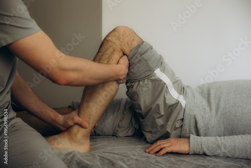 Konstfotografi Physiotherapist manipulating patient leg for rehabilitation during therapy