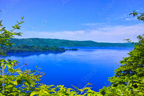 新緑の青森県十和田市にある十和田湖、新緑の中に浮かぶ十和田湖の景観
